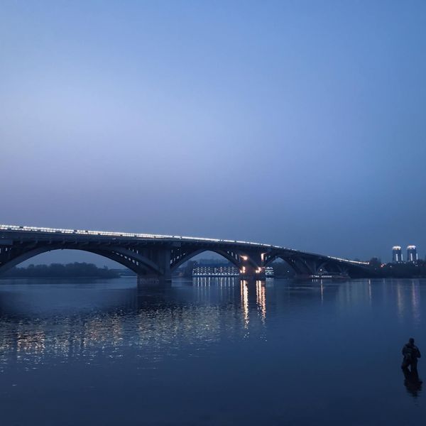 Person meditating peacefully in a calm, modern setting with blue ambient light.